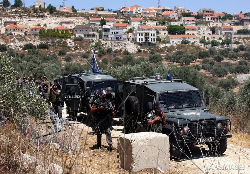 Israeli forces take position during clashes with Palestinian villagers following a protest against the closure of a road during the second Intifada by Jewish settlers from the nearby settlement of Kadumim, on July 01, 20...