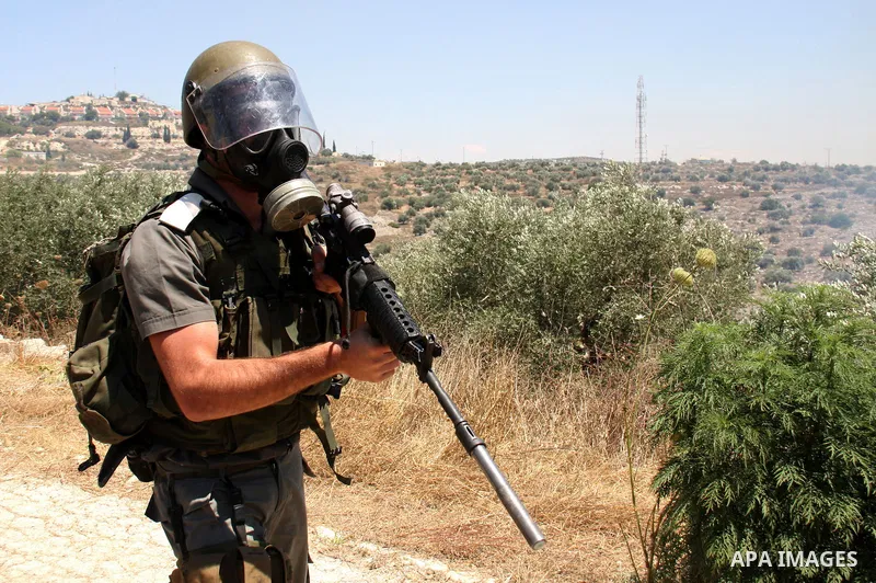 An Israeli soldier takes position during clashes with Palestinian villagers following a protest against the closure of a road during the second Intifada by Jewish settlers from the nearby settlement of Kadumim, on July 0...