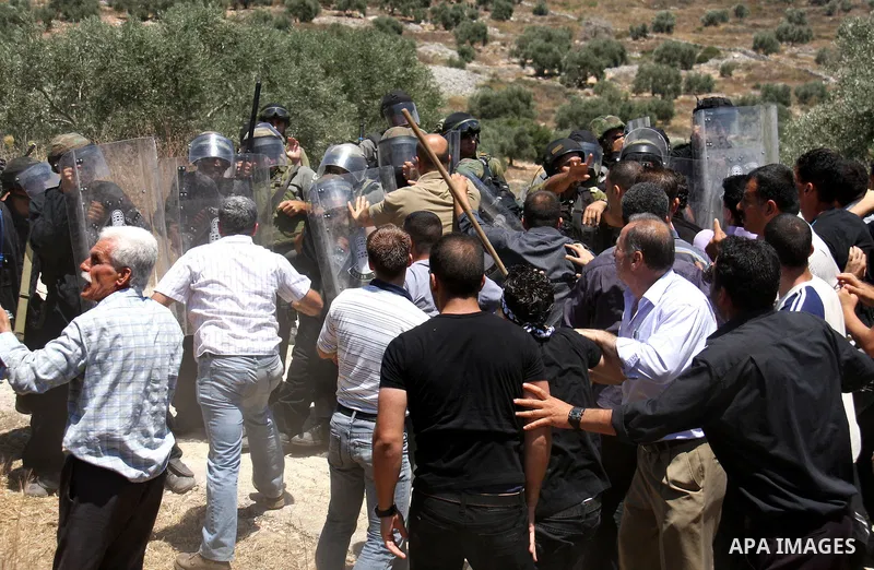 Israeli forces and Palestinian villagers scuffle during a protest against the closure of a road during the second Intifada by Jewish settlers from the nearby settlement of Kadumim , on July 01, 2011 in the West Bank vill...