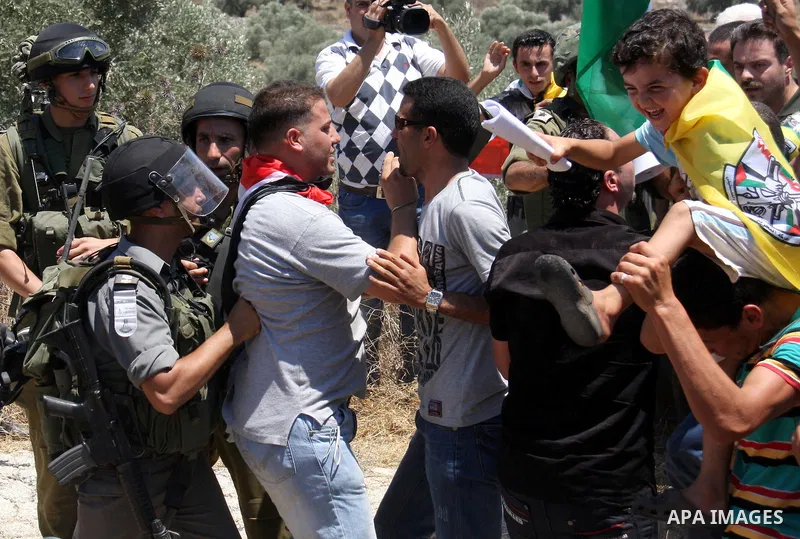 Israeli forces and Palestinian villagers scuffle during a protest against the closure of a road during the second Intifada by Jewish settlers from the nearby settlement of Kadumim , on July 01, 2011 in the West Bank vill...