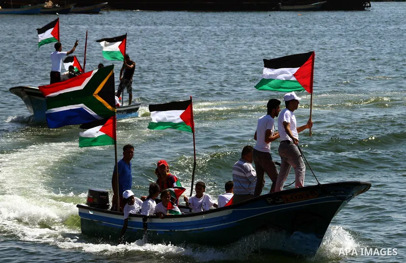 Palestinians ride on boats at the port of Gaza City during a rally in support of the Gaza-bound international Freedom Flotilla hoping to breach Israel's sea blockade on Gaza as it was banned by Greece from setting sail o...