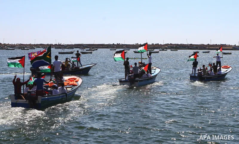 Palestinians ride on boats at the port of Gaza City during a rally in support of the Gaza-bound international Freedom Flotilla hoping to breach Israel's sea blockade on Gaza as it was banned by Greece from setting sail o...