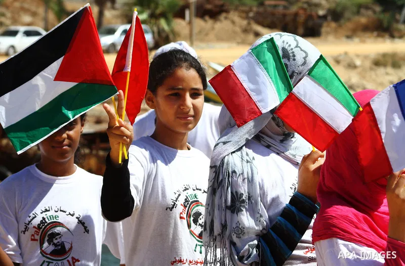 Palestinian children wave Palestinian flags along with the national flags of activists taking part in the Gaza-bound international Freedom Flotilla hoping to breach Israel's sea blockade on Gaza during a rally in Gaza Ci...