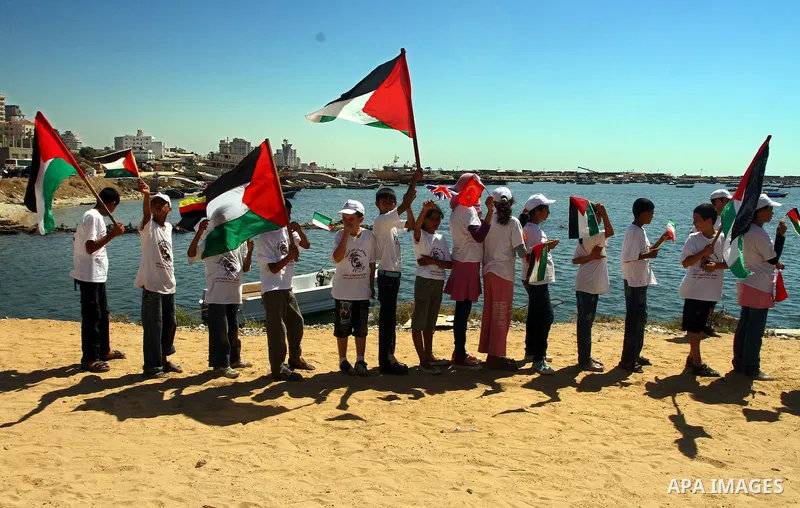 Palestinian children wave Palestinian flags along with the national flags of activists taking part in the Gaza-bound international Freedom Flotilla hoping to breach Israel's sea blockade on Gaza during a rally in Gaza Ci...