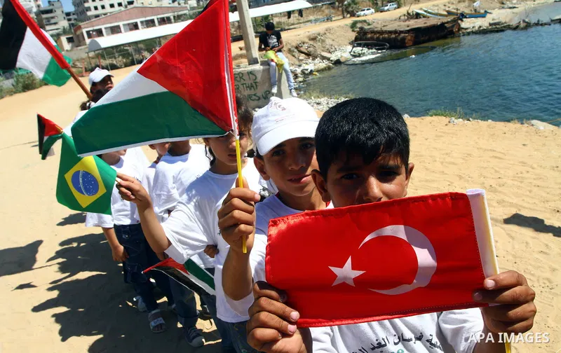 Palestinian children wave Palestinian flags along with the national flags of activists taking part in the Gaza-bound international Freedom Flotilla hoping to breach Israel's sea blockade on Gaza during a rally in Gaza Ci...