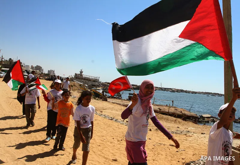 Palestinian children wave Palestinian flags along with the national flags of activists taking part in the Gaza-bound international Freedom Flotilla hoping to breach Israel's sea blockade on Gaza during a rally in Gaza Ci...