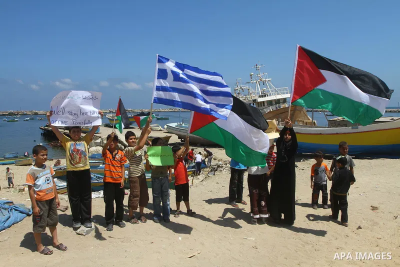 Palestinian children wave Palestinian flags along with the national flags of activists taking part in the Gaza-bound international Freedom Flotilla hoping to breach Israel's sea blockade on Gaza during a rally in Gaza Ci...