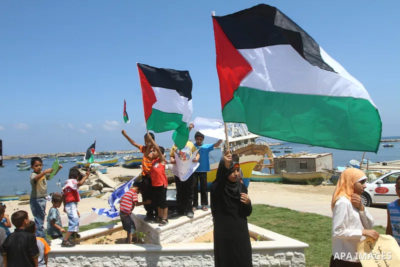 Palestinian children wave Palestinian flags along with the national flags of activists taking part in the Gaza-bound international Freedom Flotilla hoping to breach Israel's sea blockade on Gaza during a rally in Gaza Ci...