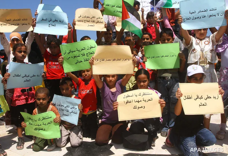 Palestinian children wave Palestinian flags and banners during a rally in Gaza City in support of the international Freedom Flotilla hoping to breach Israel's sea blockade on Gaza as it remained banned by Greece from set...