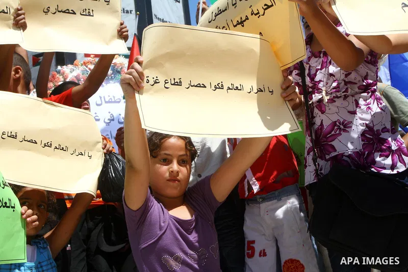 Palestinian children wave banners during a rally in Gaza City in support of the international Freedom Flotilla hoping to breach Israel's sea blockade on Gaza as it remained banned by Greece from setting sail on July 3, 2...