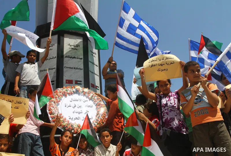 Palestinian children wave Palestinian flags along with the national flags of activists taking part in the Gaza-bound international Freedom Flotilla hoping to breach Israel's sea blockade on Gaza during a rally in Gaza Ci...