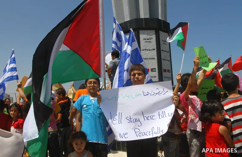 Palestinian children wave Palestinian flags along with the national flags of activists taking part in the Gaza-bound international Freedom Flotilla hoping to breach Israel's sea blockade on Gaza during a rally in Gaza Ci...