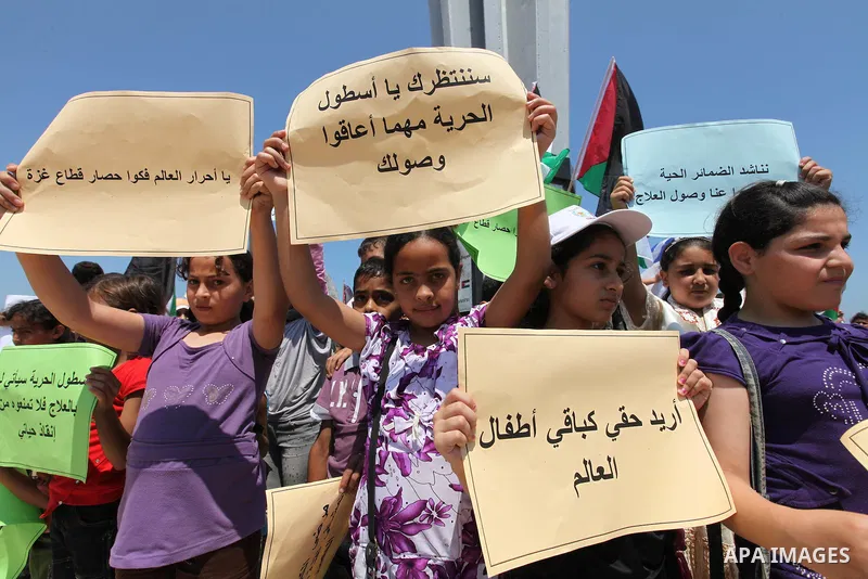 Palestinian children wave Palestinian flags and banners during a rally in Gaza City in support of the international Freedom Flotilla hoping to breach Israel's sea blockade on Gaza as it remained banned by Greece from set...