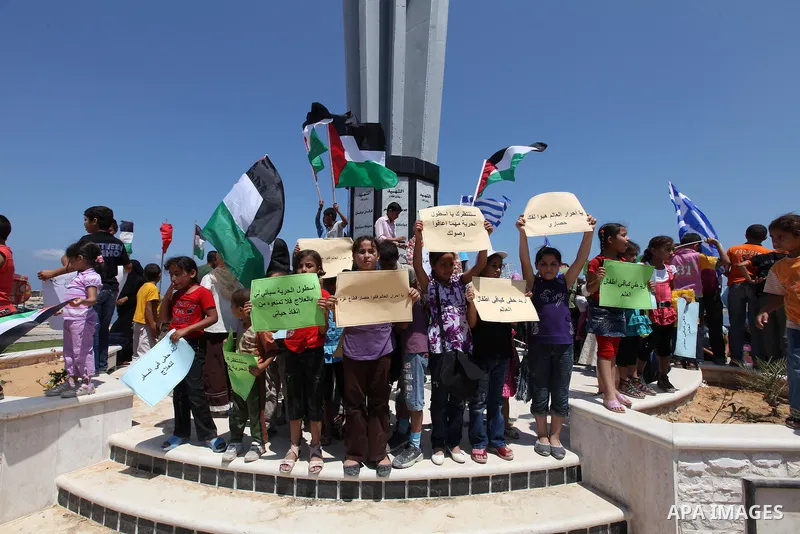 Palestinian children wave Palestinian and Greek flags during a rally in Gaza City in support of the international Freedom Flotilla hoping to breach Israel's sea blockade on Gaza as it remained banned by Greece from setti...
