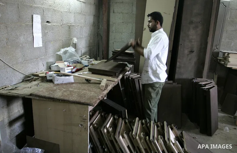 A Palestinian carpenter works at their furniture carpentry workshop in Rafah, southern Gaza Strip on July 3,2011. Photo by Abed Rahim Khatib