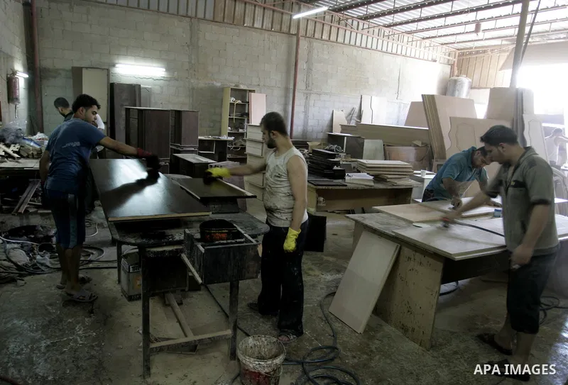 Palestinian carpenters work at their furniture carpentry workshop in Rafah, southern Gaza Strip on July 3,2011. Photo by Abed Rahim Khatib
