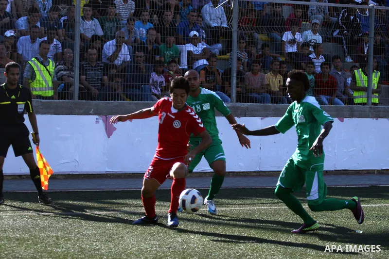 Palestinian player and Afghanistan player challenge for the ball during a soccer match between the Palestinian and Afghanistan national teams in the West bank city of Ramallah, Sunday July 3, 2011. The Palestinian nation...