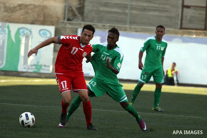 Palestinian player and Afghanistan player challenge for the ball during a soccer match between the Palestinian and Afghanistan national teams in the West bank city of Ramallah, Sunday July 3, 2011. The Palestinian nation...
