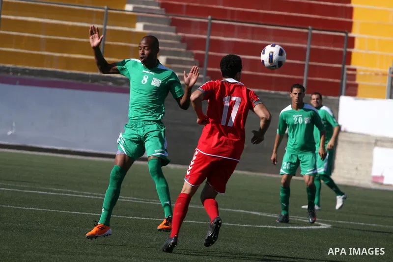 Palestinian player and Afghanistan player challenge for the ball during a soccer match between the Palestinian and Afghanistan national teams in the West bank city of Ramallah, Sunday July 3, 2011. The Palestinian nation...