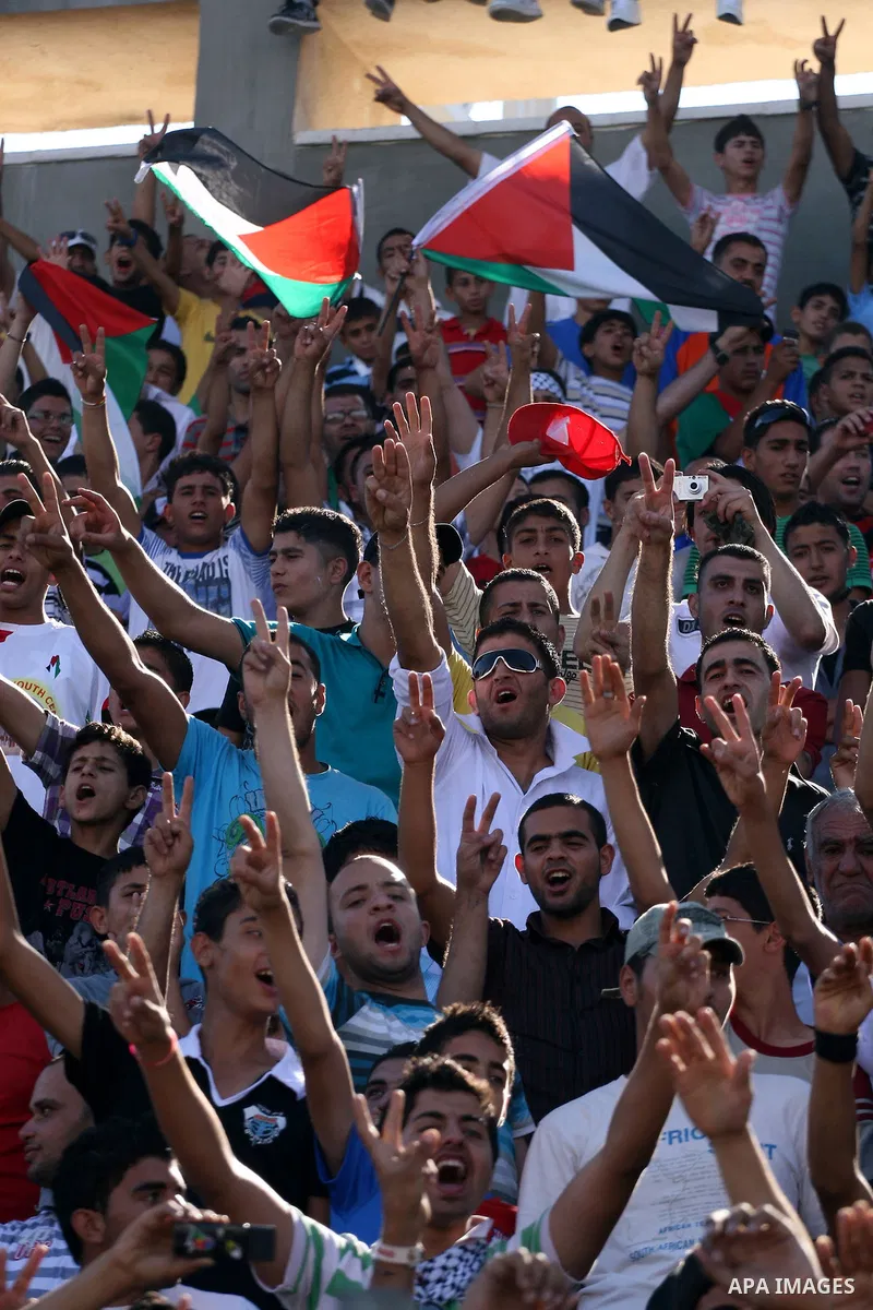 Palestinians watch their national soccer team play against Afghanistan national team in the West bank city of Ramallah, Sunday July 3, 2011. The Palestinian national soccer team drew 1-1 against Afghanistan on Sunday, a...
