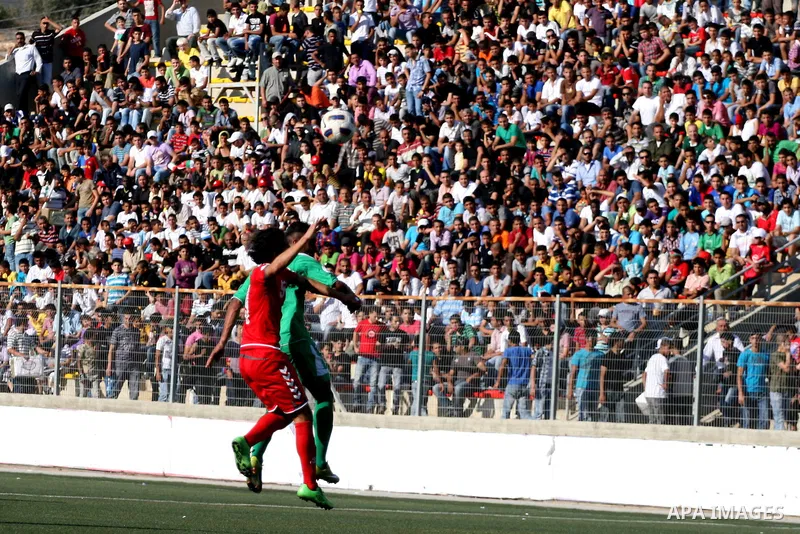 Palestinian player and Afghanistan player challenge for the ball during a soccer match between the Palestinian and Afghanistan national teams in the West bank city of Ramallah, Sunday July 3, 2011. The Palestinian nation...