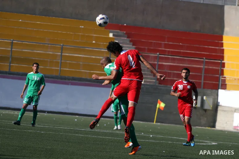 Palestinian player and Afghanistan player challenge for the ball during a soccer match between the Palestinian and Afghanistan national teams in the West bank city of Ramallah, Sunday July 3, 2011. The Palestinian nation...