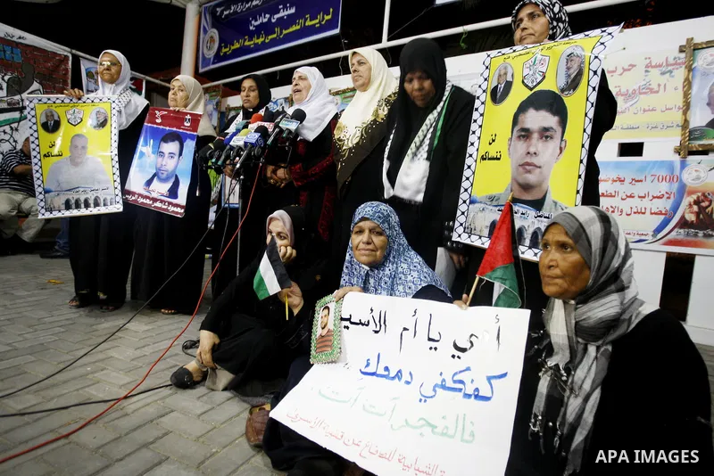 Relatives of Palestinian prisoners hold their pictures as they prepare to sleep at Gaza City's Red Cross offices on July 3,2011, during a protest calling for the release of Palestinian prisoners from Israeli jails. Photo...