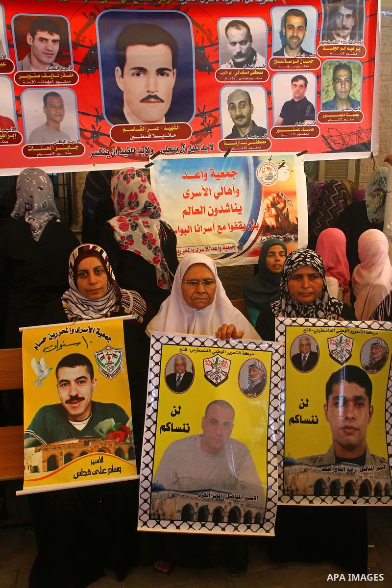 Palestinians hold pictures of their relatives held in Israeli jails during a protest calling for their release in front of the Red Cross in Gaza city on July 4, 2011. Israel currently holds about 5,600 Palestinian prison...