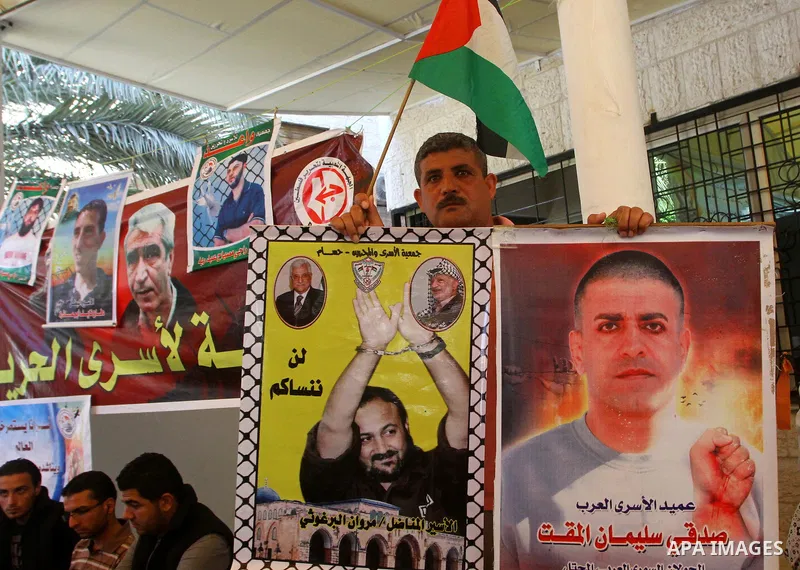 Palestinians hold pictures of their relatives held in Israeli jails during a protest calling for their release in front of the Red Cross in Gaza city on July 4, 2011. Israel currently holds about 5,600 Palestinian prison...