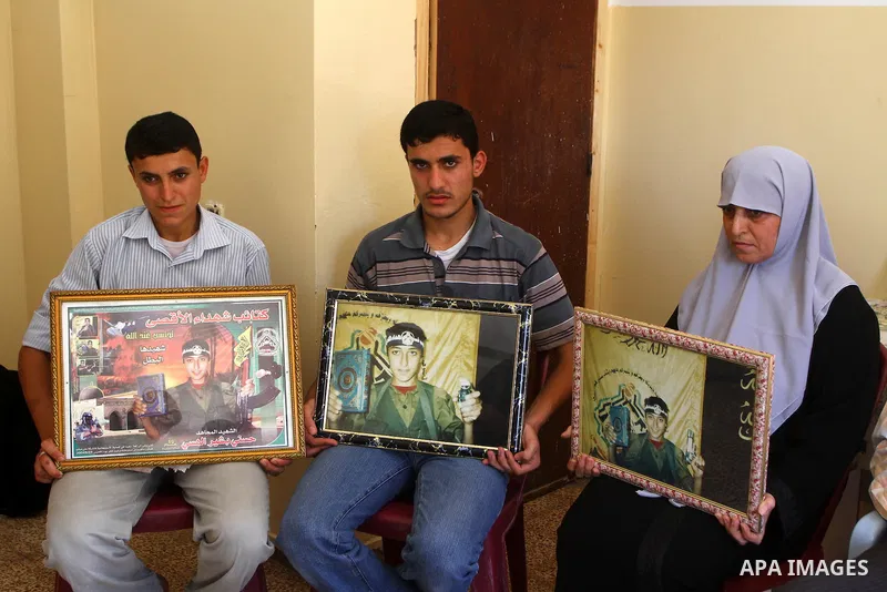 Relatives of the Palestinian Hosni Al-Hasi, who killed during a military attack in the former settlement of Doghit, hold his picture at their home in Gaza city on July 4,2011 .The Palestinian Authority and Israel agreed...