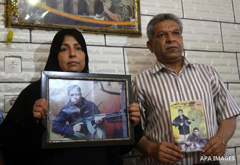 Mother and father of the Palestinian Nabil Masoud, who killed during a military attack in Israel, hold his picture at their home in Gaza city on July 4,2011 .The Palestinian Authority and Israel agreed that 84 bodies of...
