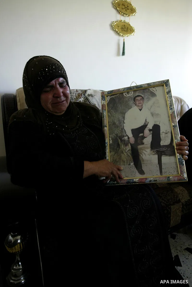 Palestinian relatives of Zeid Hanani hold his picture on July 4, 2011, in the West Bank town of Nablus, after Palestinian minister for civil affairs Hussein al-Sheikh announced that Israel is to release the bodies of 84...