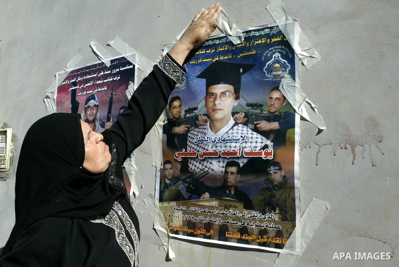 Palestinian relatives of Yousef Hanani hold his picture on July 4, 2011, in the West Bank town of Nablus, after Palestinian minister for civil affairs Hussein al-Sheikh announced that Israel is to release the bodies of 8...