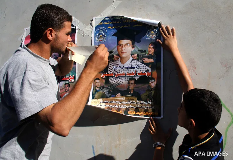 Palestinian relatives of Yousef Hanani hold his picture on July 4, 2011, in the West Bank town of Nablus, after Palestinian minister for civil affairs Hussein al-Sheikh announced that Israel is to release the bodies of 8...