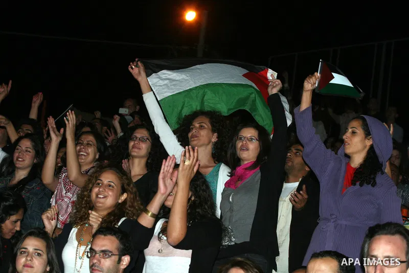 Palestinians attend a concert by Egyptian soft rock band Wast El Balad (lit: Downtown) during the opening ceremony of the 13th Palestine International Festival, in the West bank city of Ramallah on July 4, 2011. Where or...