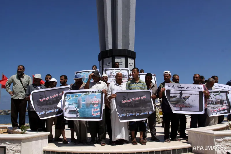 Palestinian fishermen hold banners during a rally in Gaza City in support of the international Freedom Flotilla hoping to breach Israel's sea blockade on Gaza as it remained banned by Greece from setting sail on July 5,...