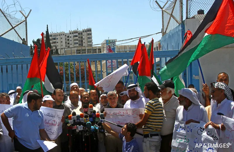 Palestinians hold their national flags during a protest in front of UNRWA headquarters in Gaza city on July 5, 2011. Dozens of Palestinians gather to protest against the UNRWA decision to change its name. Photo by Ashraf...