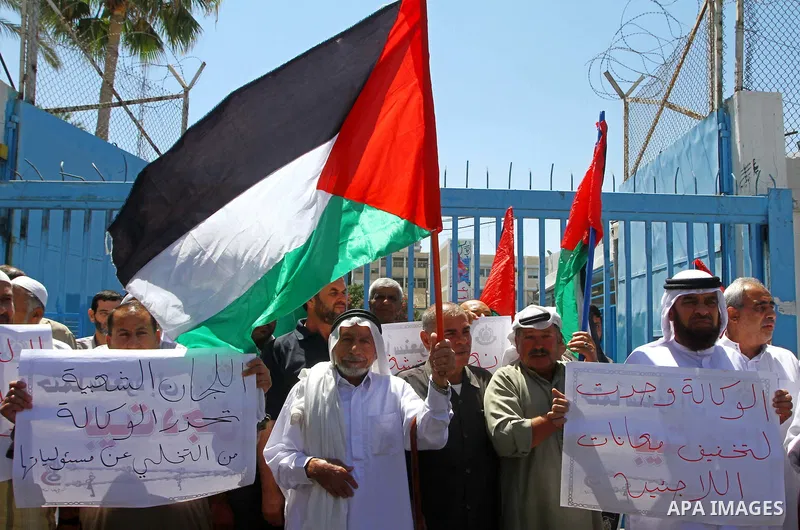Palestinians hold their national flags during a protest in front of UNRWA headquarters in Gaza city on July 5, 2011. Dozens of Palestinians gather to protest against the UNRWA decision to change its name. Photo by Ashraf...