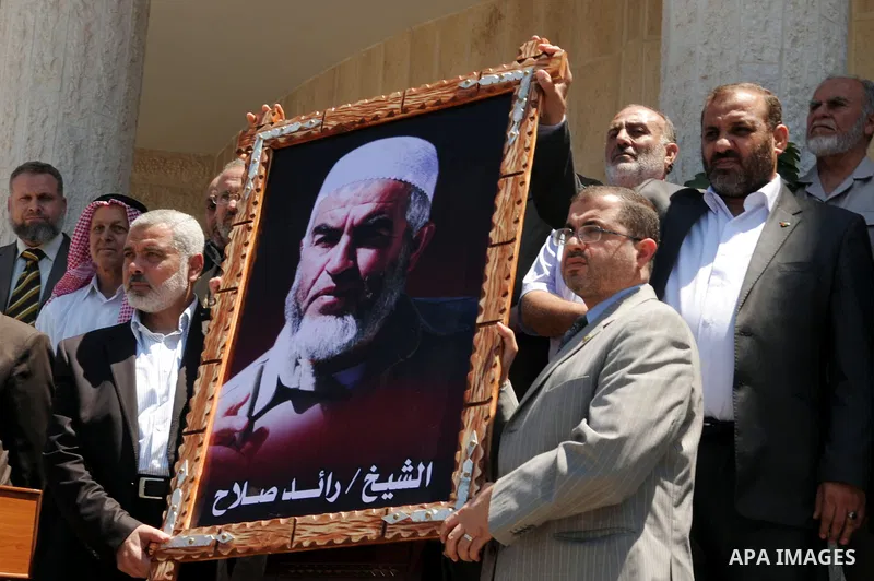 Palestinian Prime Minister in Gaza Strip, Ismail Haniya carries a picture of Sheikh Raed Salah in support with him in Gaza city o July 5, 2011. After the controversial Arab-Israeli Islamist leader was arrested in London...