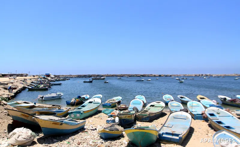 A Palestinian fisherman works on his boat in the port of Gaza City, Tuesday, July 5, 2011, as pro-Palestinian activists from an international flotilla banned from setting sail for Gaza by Greek authorities occupied the S...
