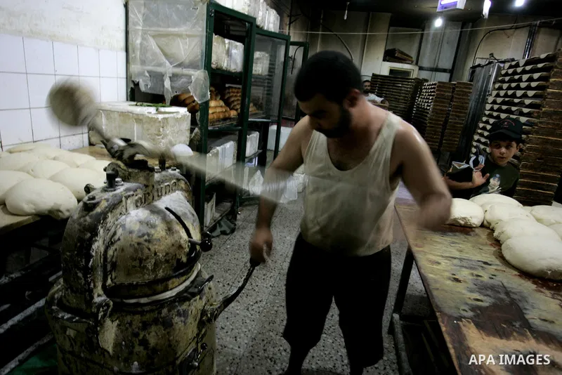 A Palestinian baker prepares bread at his bakery in Rafah, southern Gaza Strip on July 5,2011. Photo by Abed Rahim Khatib