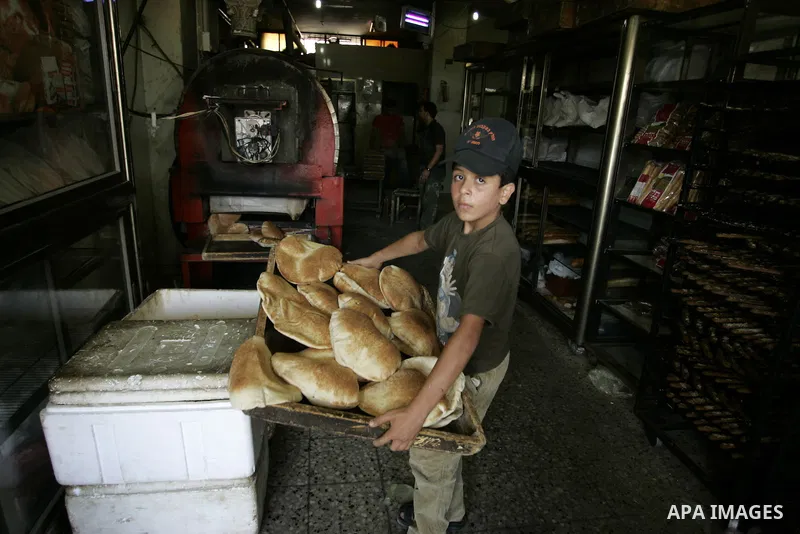 A Palestinian baker prepares bread at his bakery in Rafah, southern Gaza Strip on July 5,2011. Photo by Abed Rahim Khatib