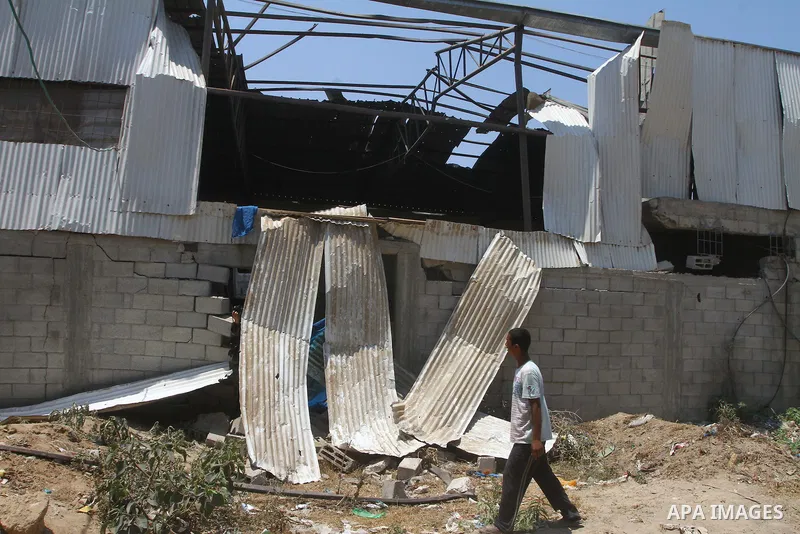Palestinian youths inspect damage at a fodder storage following an Israeli air strike east of Gaza City, early Wednesday, July 6, 2011. Photo by Ashraf Amra