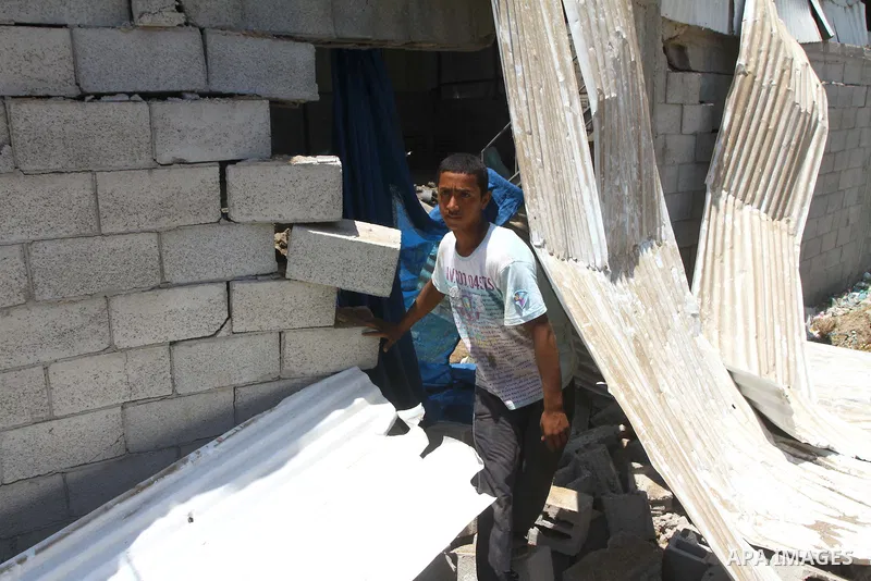 Palestinian youths inspect damage at a fodder storage following an Israeli air strike east of Gaza City, early Wednesday, July 6, 2011. Photo by Ashraf Amra