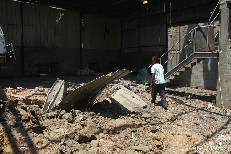 Palestinian youths inspect damage at a fodder storage following an Israeli air strike east of Gaza City, early Wednesday, July 6, 2011. Photo by Ashraf Amra