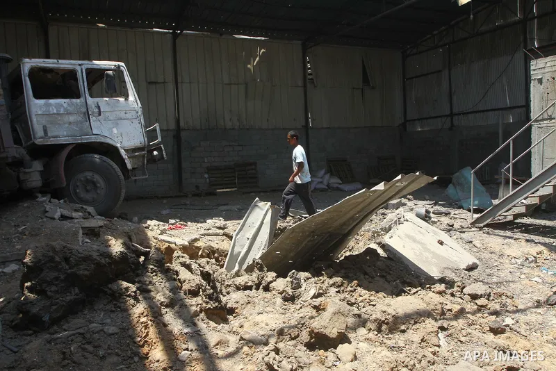 Palestinian youths inspect damage at a fodder storage following an Israeli air strike east of Gaza City, early Wednesday, July 6, 2011. Photo by Ashraf Amra