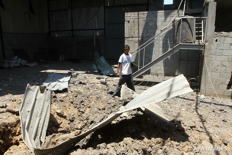 Palestinian youths inspect damage at a fodder storage following an Israeli air strike east of Gaza City, early Wednesday, July 6, 2011. Photo by Ashraf Amra