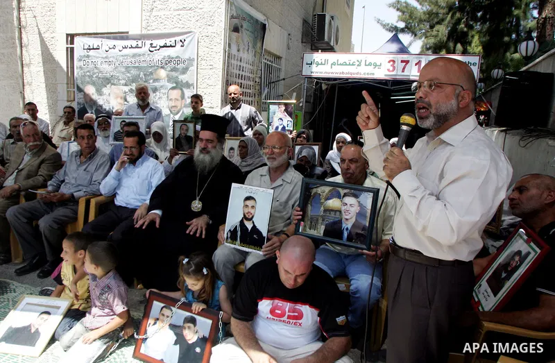 Pictures of Palestinian prisoners held in Israeli jails are held by their relatives during a protest in the Sheikh Jarrah neighbourhood in East Jerusalem July 6, 2011, calling for their release. Photo by Mahfouz Abu Turk