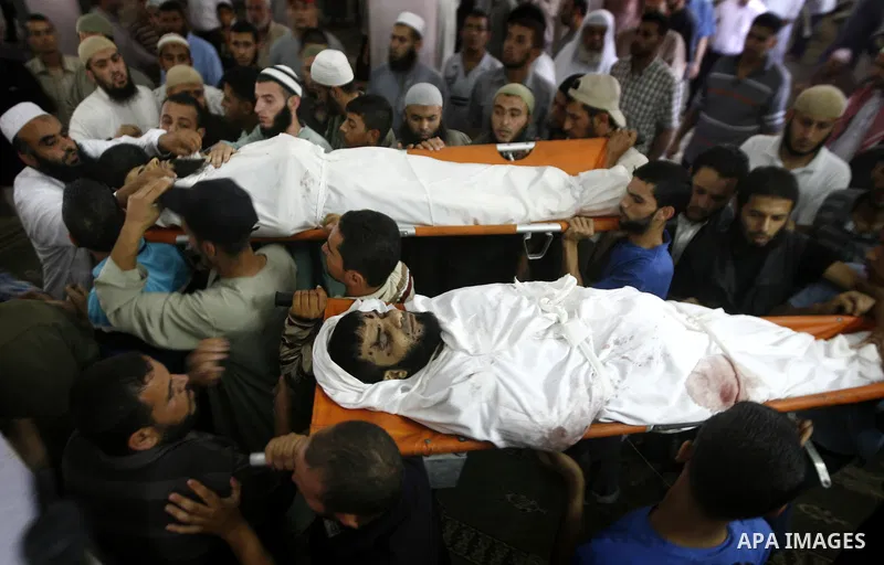 Palestinian relatives and friends of Kamal Hamdan Muammar and Mohammed Said Abu Jazar, both 28-years-old, carry them following prayers at the mosque in the Rafah refugee camp, in the southern of Gaza Strip, on July 6, 20...