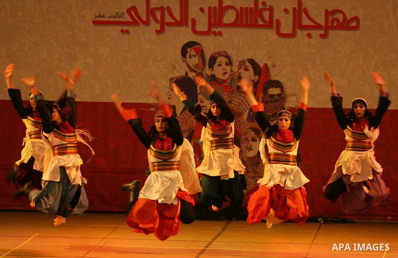 Dancers of the El-Funoun Palestinian Popular Dance Troupe perform on the third day of the 13th Palestine International Festival in the West Bank city of Ramallah on July 6, 2011. The festival, which features music and da...